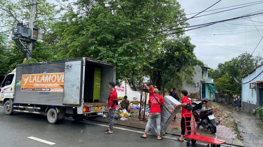 Nguoi dan van chuyen do len xe tai de chuyen den noi o moi. Ảnh: Anh Tu