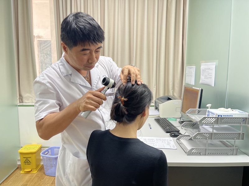 Bac si Ha kham cho mot benh nhan bi rung toc. Anh: BVCC