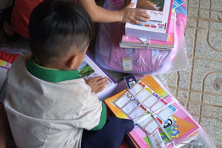 Cac em hoc sinh can than xem tung mon qua ma doan CTXH trao tang. Anh: Tran Thi