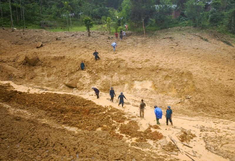 Nguoi dan mien nui Tra Tan, Da Nang hoi ha so tan khoi vung sat lo, lu quet, bo lai dang sau nhung mai nha tan hoang. Anh: Truong An