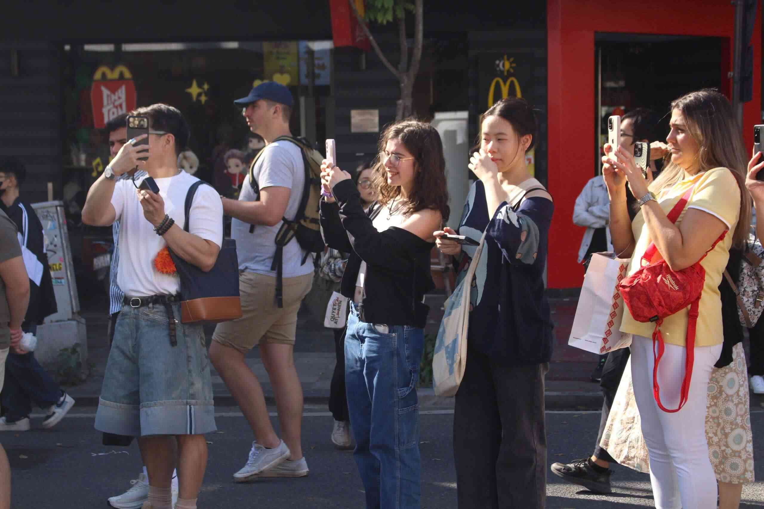 Turiștii internaționali urmăresc cu entuziasm parada Ao Dai. Foto: Le Tuyen