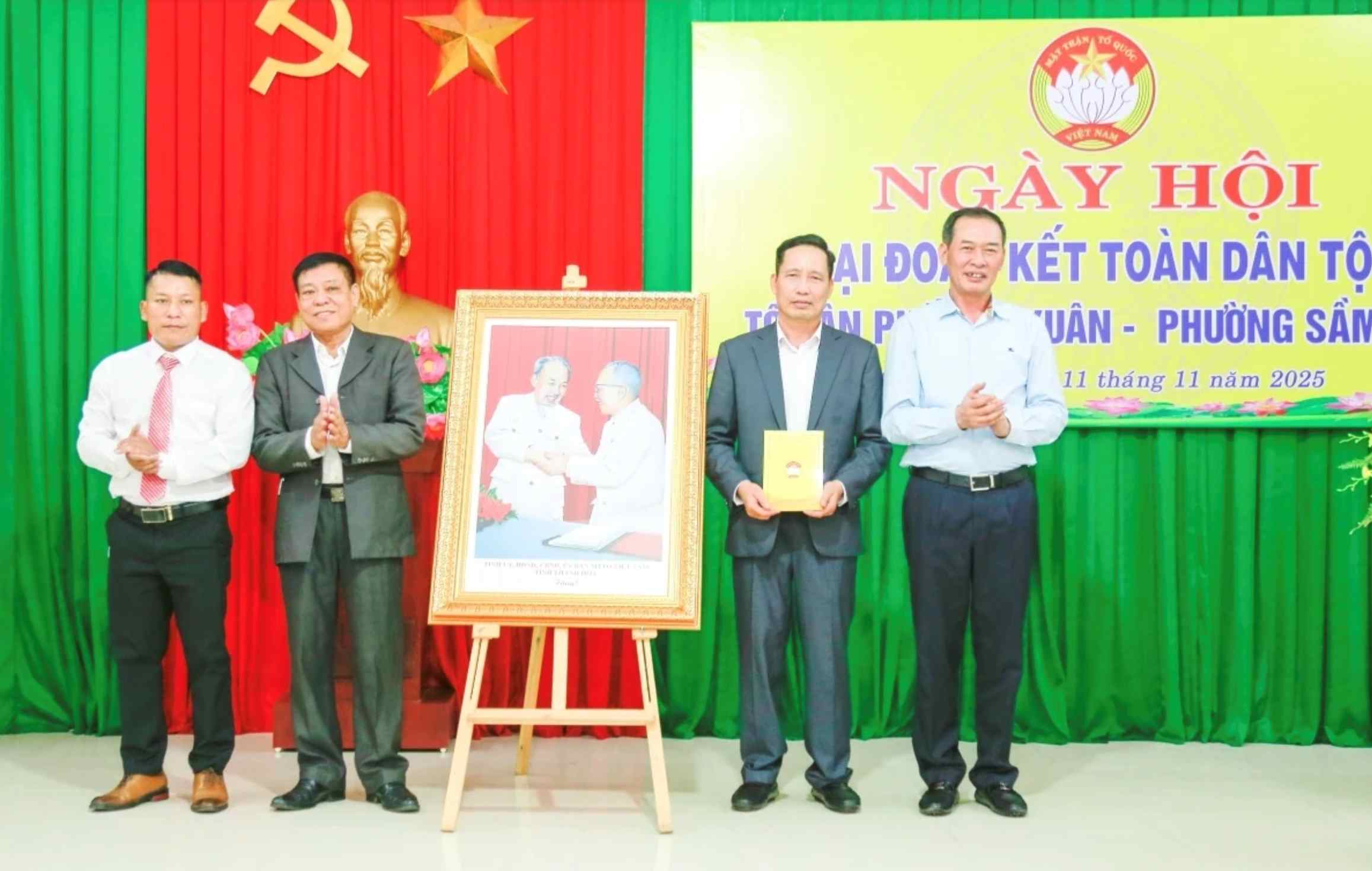 El Vicesecretario del Comite Provincial del Partido el Presidente del Comite del Frente de la Patria de la provincia Trinh Tuan Sinh (derecha de la foto) entrego a los funcionarios y el pueblo del grupo residencial Tho Xuan la foto 'Bac Ho con bac Ton' en el Dia de la Gran Unidad Nacional con los funcionarios y el pueblo del grupo residencial Tho Xuan en el barrio de Sam Son. Foto Hai Dang