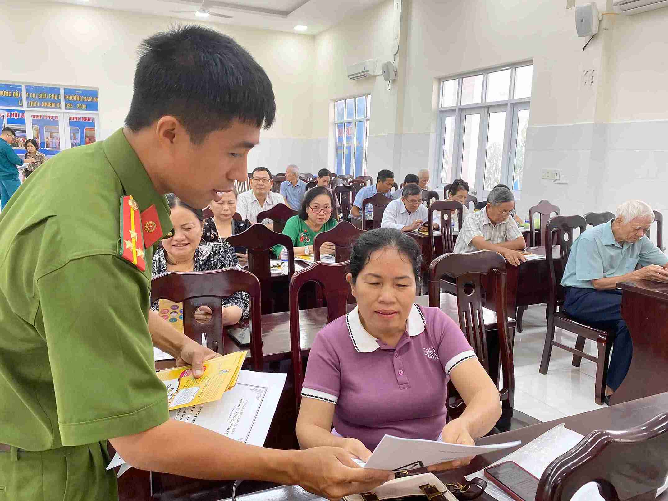 Soldados de policia distribuyen materiales de propaganda sobre documentos legales a mas de 100 funcionarios miembros del sindicato y trabajadores. Foto: Thu Huong