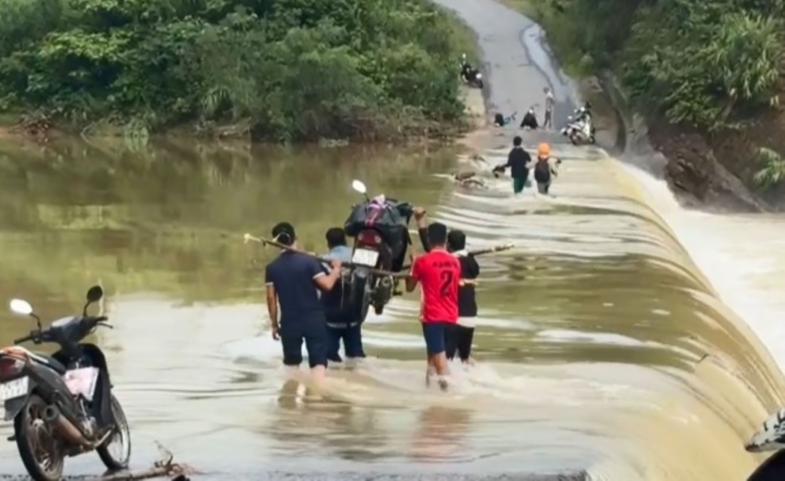 The way to Cat and Tria schools, teachers had to ask people to take their vehicles across the flooded bridge. Photo: Dinh Sam