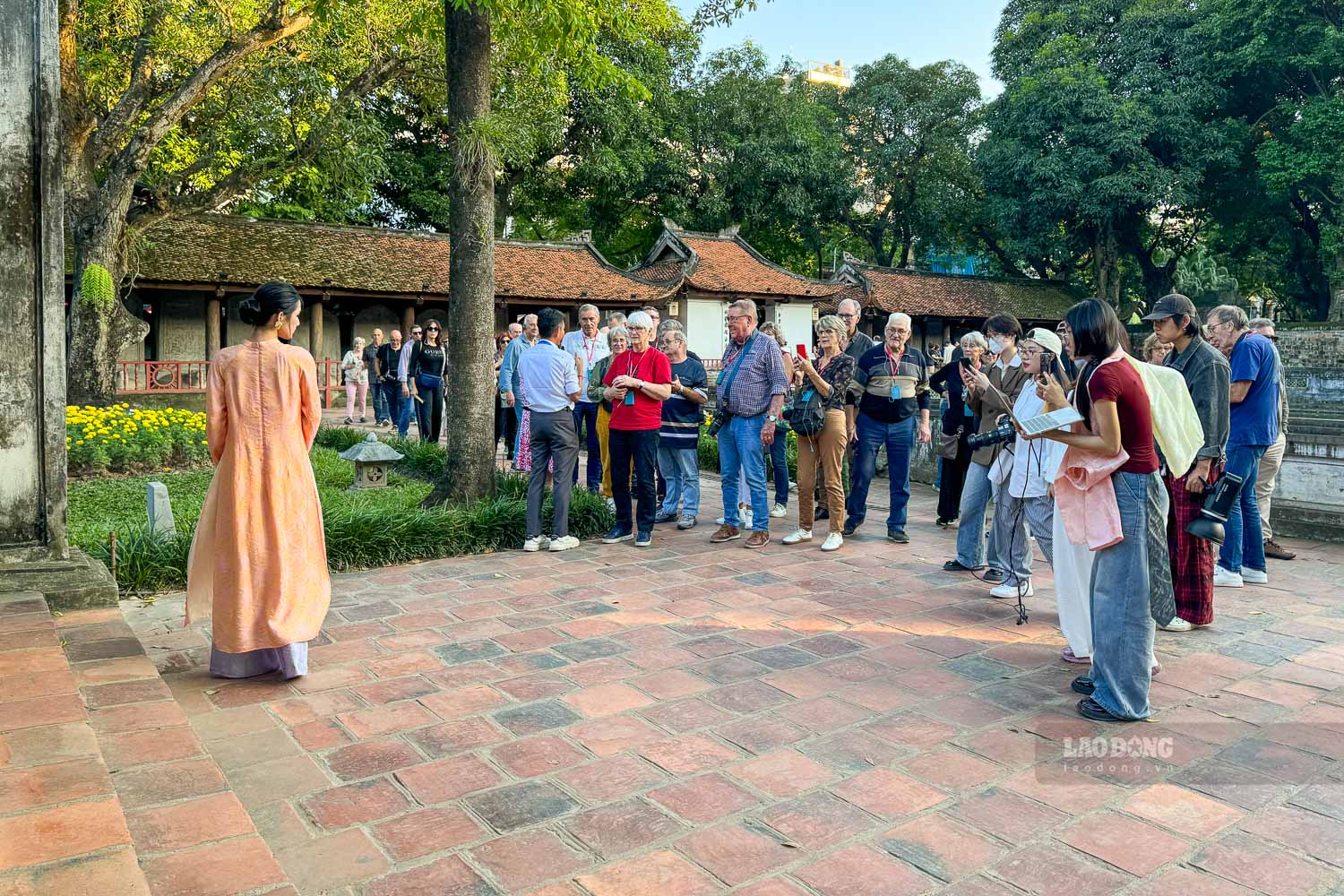 Nhieu nhom du khach nuoc ngoai kha thich thu khi dung lai theo doi nguoi mau anh Tran Ly tao dang trong nhung bo ao dai moi la.