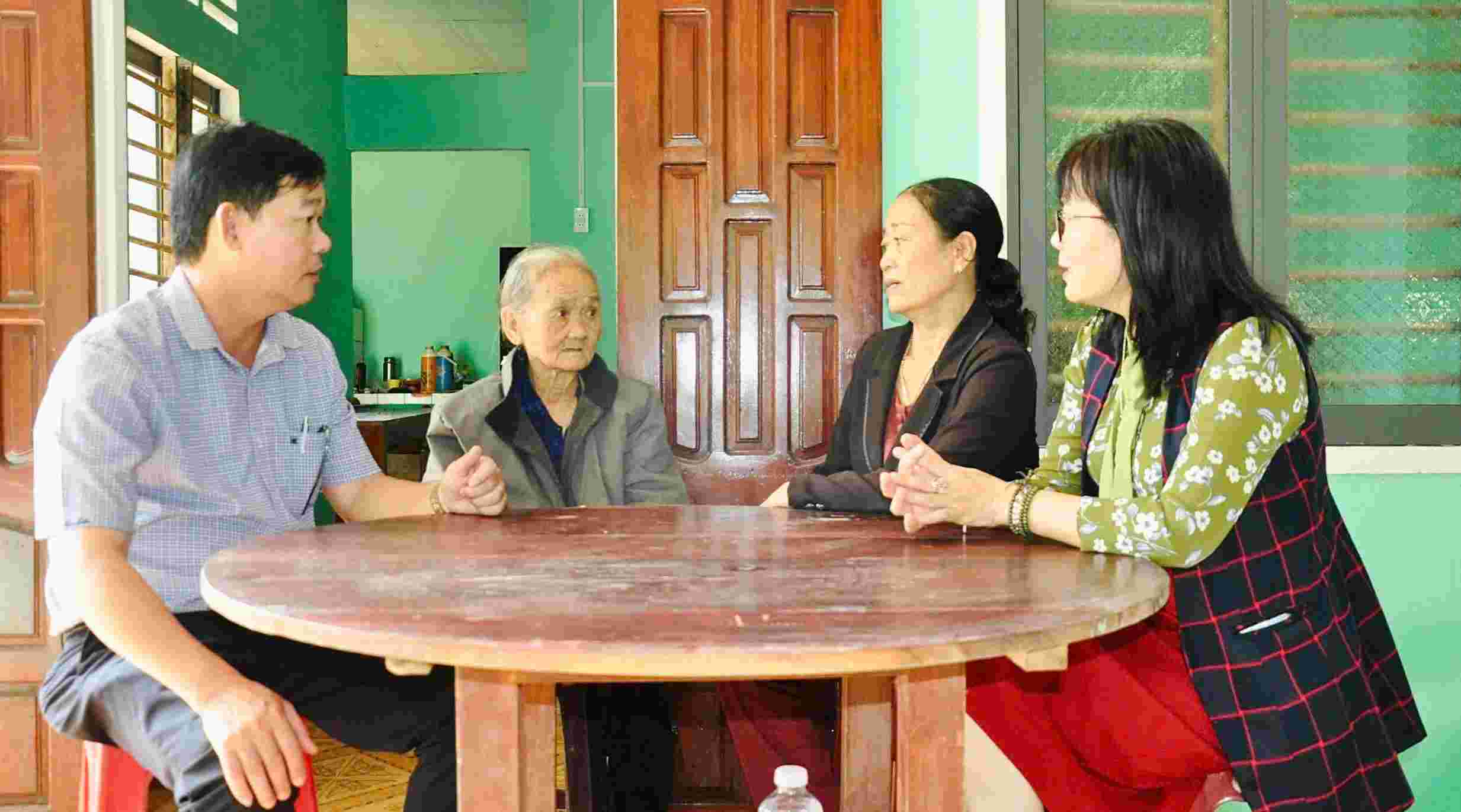 La Sra. Dang Thi Dich (segunda desde la izquierda) en la comuna de Van Tuong comparte su alegria con los funcionarios del Frente por recibir apoyo para reparar sus casas. Foto: Vien Nguyen