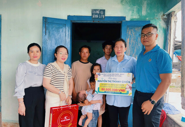 Mr. Nguyen Hoa - Chairman of the Tuy Phong Garment Factory Trade Union (right) presented support to Ms. Nguyen Thi Thanh Chien - a 55-year-old garment worker with liver cancer. Photo: Duc Lam