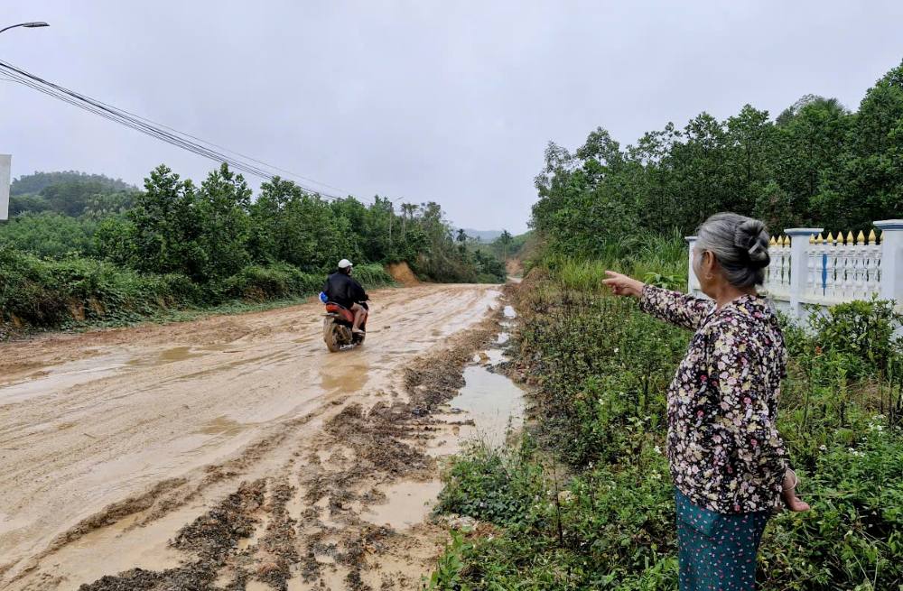 Nguoi dan buc xuc truoc canh tuyen duong lay loi bun dat. Anh: Quach Du
