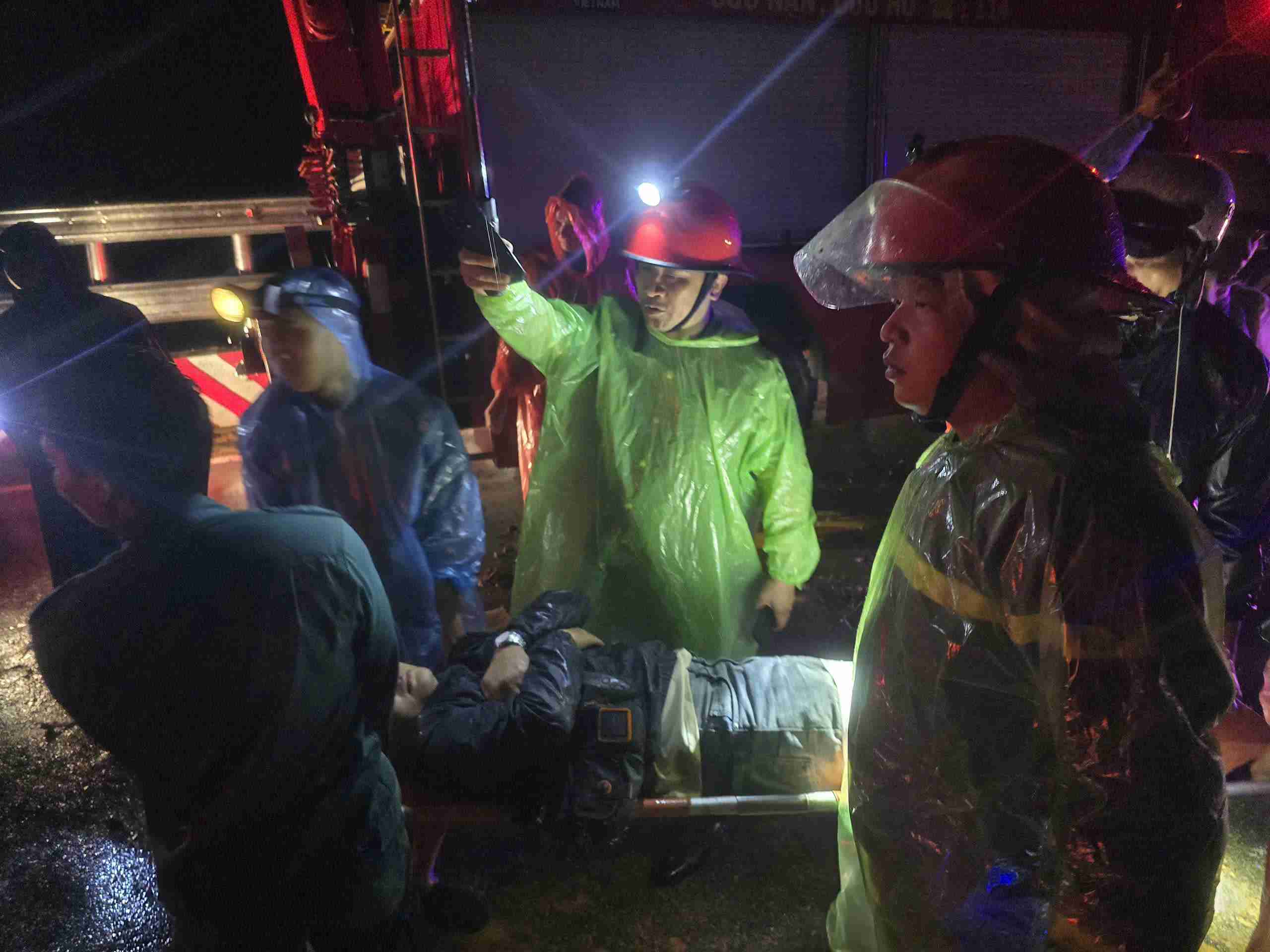 Trong dem luc luong chuc nang da dua 3 thi the nan nhan ra khoi xe khach. Hien con nhieu nguoi ket trong xe do bi da de. Anh: Huu Long