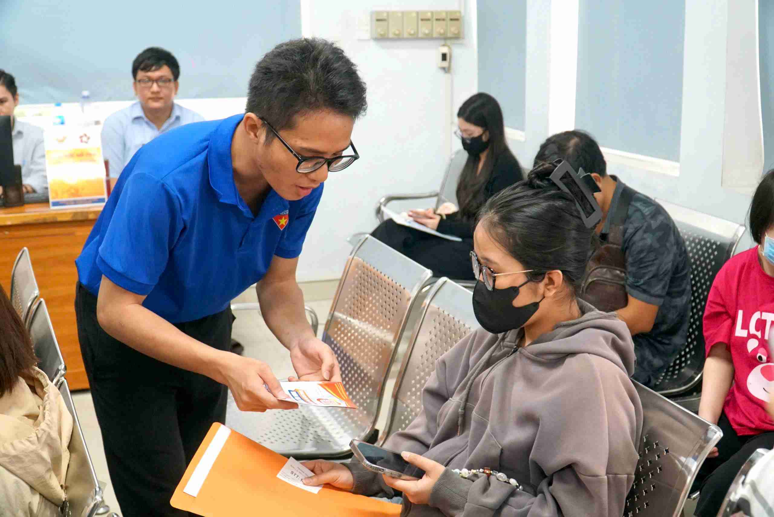 Cac doan vien thanh nien phuong Tan Hung ho tro nguoi dan su dung ung dung “Tro ly ao Hoi - Dap Phuong Tan Hung”. Anh: Minh Tam