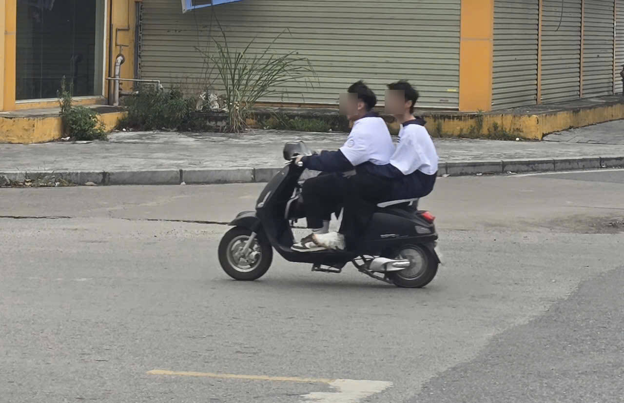 Hoc sinh dieu khien xe may, xe dap dien tham gia giao thong khong doi mu bao hiem. Anh: Nguyen Truong