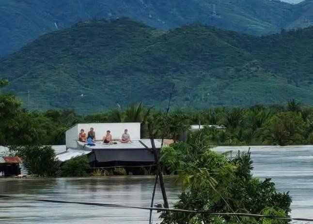 Nguoi dan o phuong Ba Ngoi tai tinh Khanh Hoa phai leo len mai nha cau cuu vi nuoc lu ngap sau. Anh: Hoai Bao