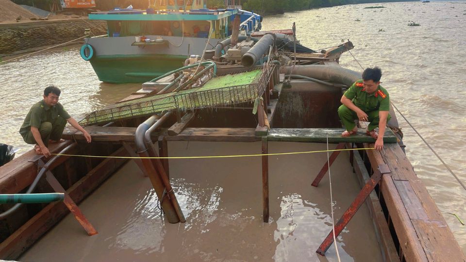 Thanh Tri Commune Police force checks a boat carrying sand of unknown origin on Tien River. Photo: Provided by the police