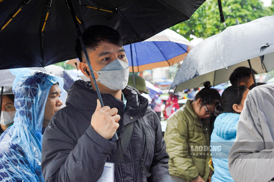 Du troi mua lon, nhung nguoi dan van kien nhan xep hang de cho vao nop ho so mua nha o xa hoi. Anh: Tuan Anh