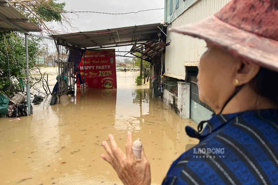 Ba Chau dung nhin ve huong can nha bi ngap trong nuoc lu. Anh: Hoai Phuong