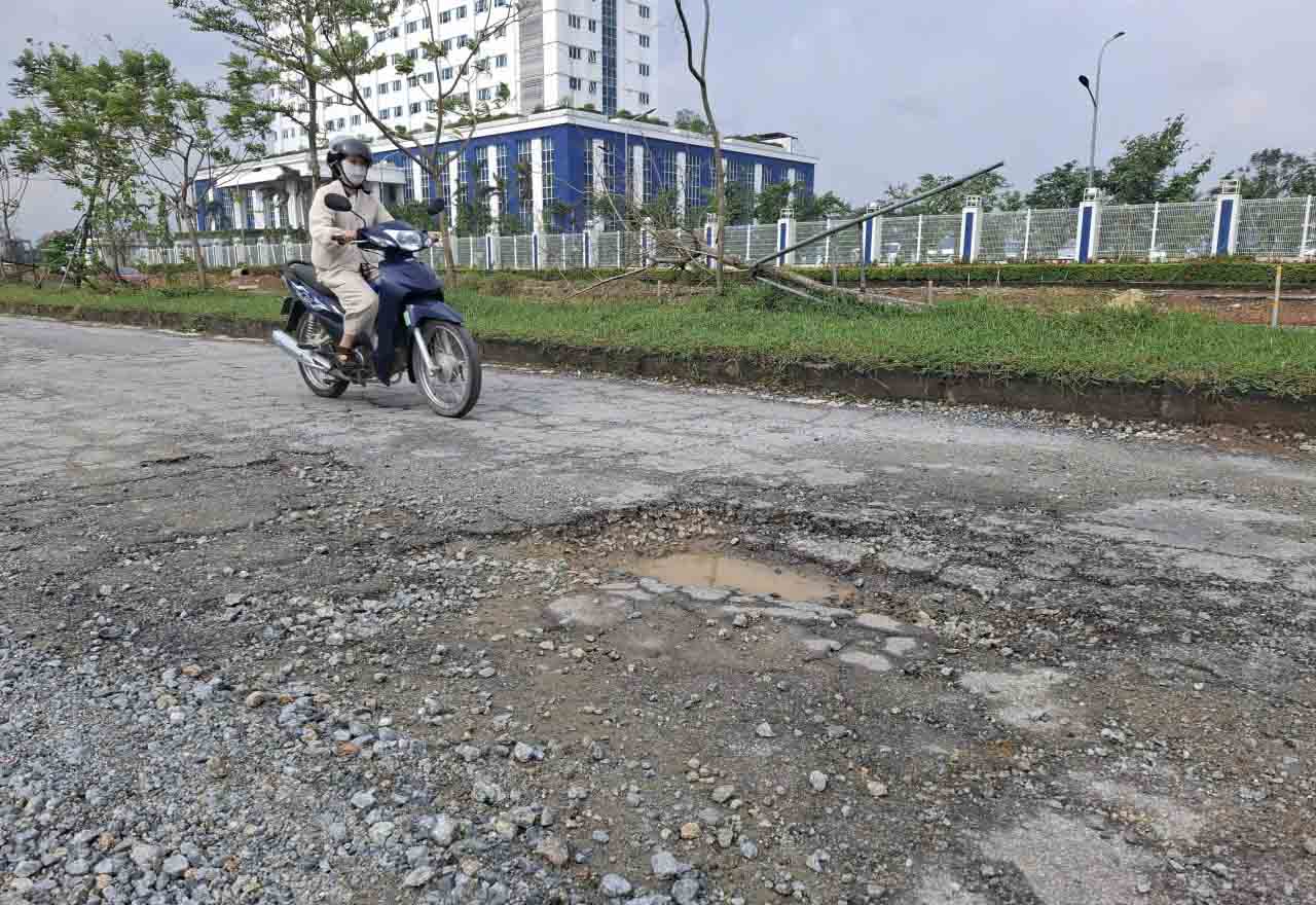 Mặt đường bong tróc đoạn gần Bệnh viện TTH. Ảnh: Trần Tuấn.