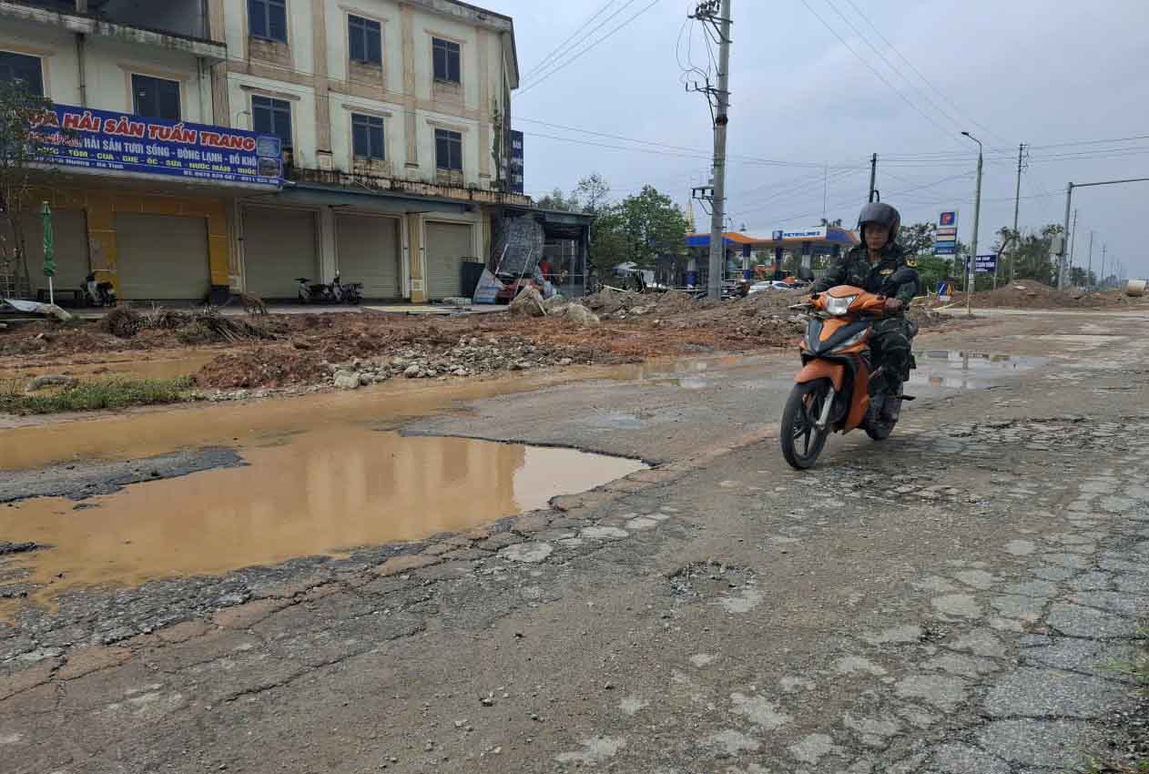 Đường bong tróc, đọng nước đi lại khó khăn đoạn trước cổng chợ Bình Hương. Ảnh: Trần Tuấn.