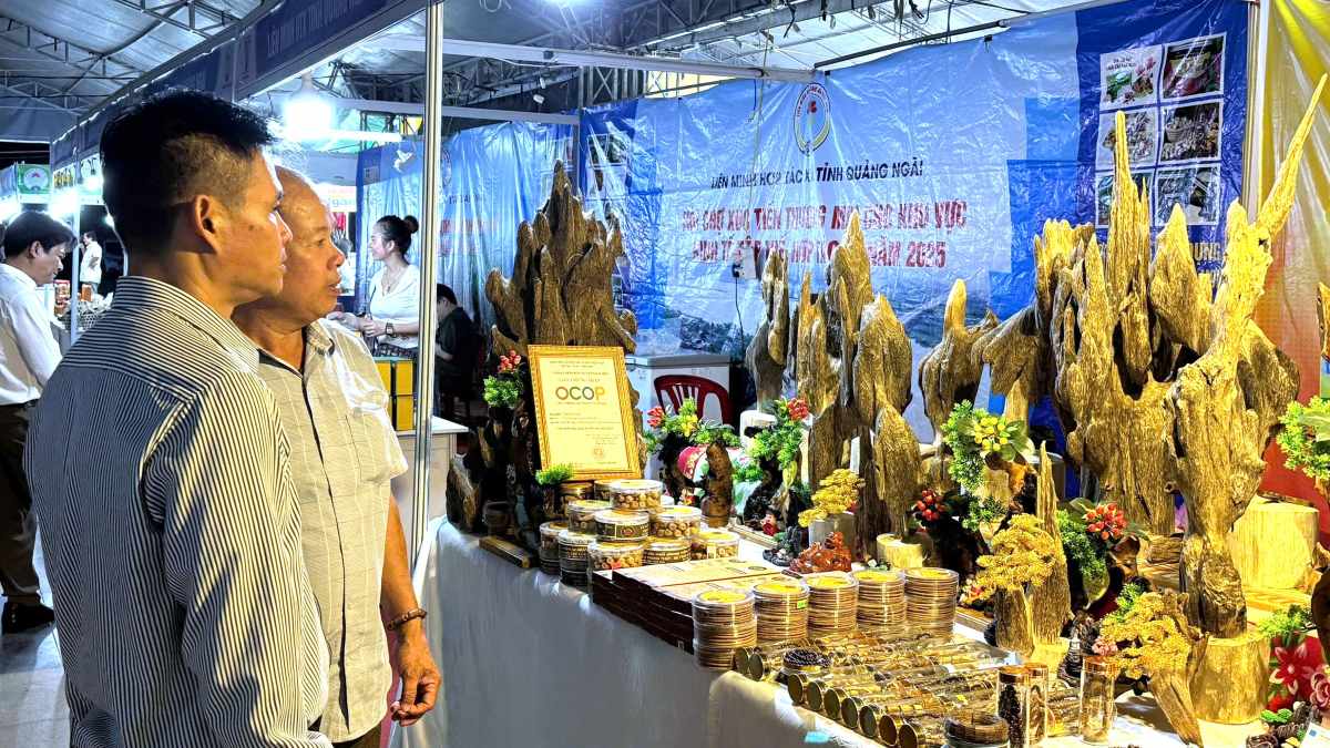 Les habitants visitent un stand exposant des produits fabriques a partir de tram huong a la foire. Photo : Thanh An