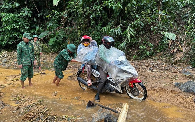 Ho tro nguoi dan di chuyen qua doan duong day bun dat sau dot mua lon. Anh: H.Nguyen