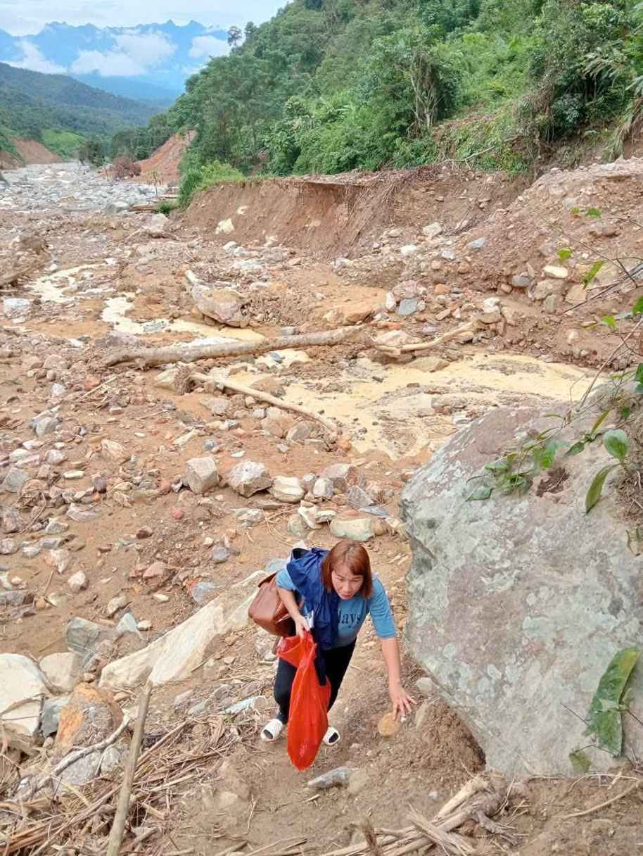 Apres les inondations l'enseignante Lo Thi Dan de l'ecole maternelle Mai Son (commune de Nhon Mai province de Nghe An) a du mal a suivre la route gravement erodee pour entrer dans l'ecole. Photo : Ngoc Anh
