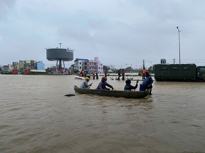 Cheo thuyen di cuu ho cuu nan nhung nguoi khac trong vung lu. Anh: Cong an