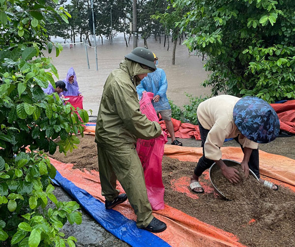 Ho tro thu don nong san cho nguoi dan khi nuoc lu dang bua vay. Anh: Cong an 