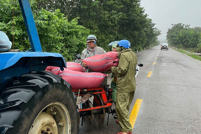 Van chuyen nong san len xe cong nong cho di tranh lu. Anh: Cong an 