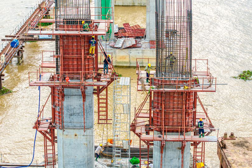 Tai tru P17 (ben phia Vinh Long), nha thau dang do be tong tru, cac cong nhan tien hanh dam be tong - day la cong doan giup ket cau cong trinh tro nen kien co, vung chac va han che duoc kha nang sut lun ve sau.