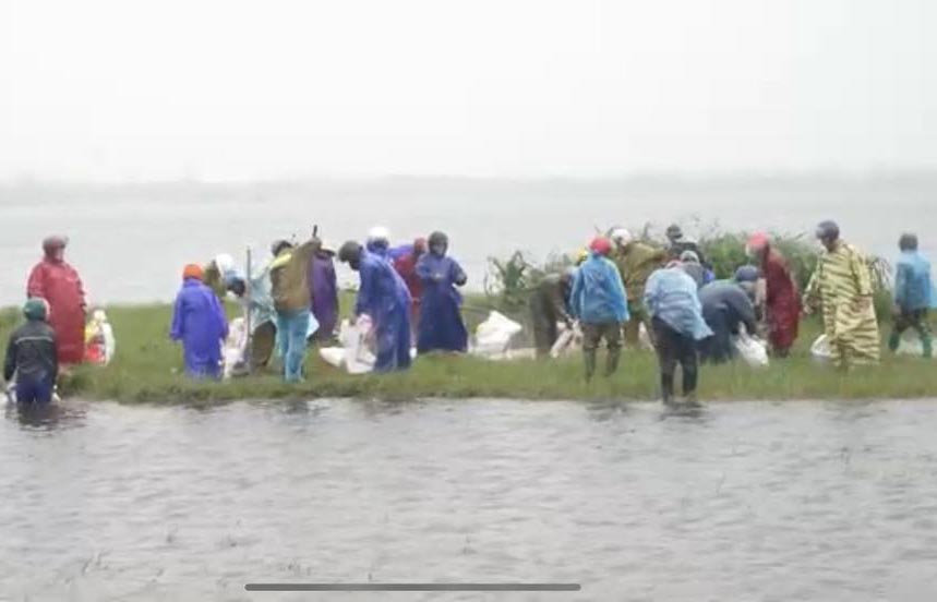 Xuc dat cat cho vao bao tai de dap doan bo bao bi vo. Anh: Tien Quang.