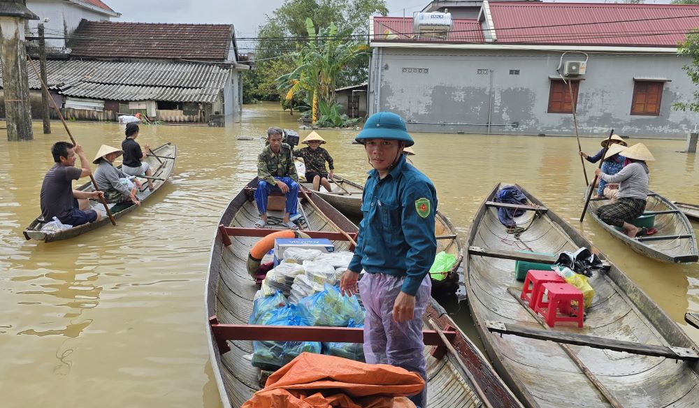 Com duoc dua vao nha tranh lu, nguoi dan cheo do den nhan com voi niem vui. Anh: Hung Tho