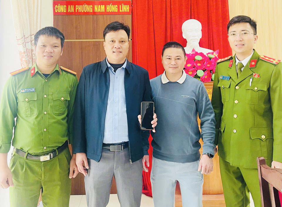 Hung 씨(왼쪽에서 두 번째)가 잘못 송금한 사람에게 7억 1 800만 동을 돌려주기 위해 계좌 이체를 하고 있습니다. 사진: Nam Hong