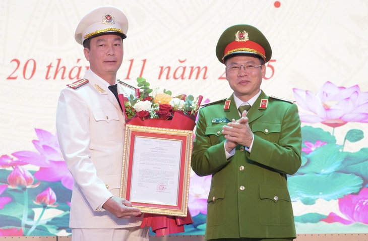 Thuong tuong Nguyen Van Long (phai), Thu truong Bo Cong an, trao quyet dinh va tang hoa chuc mung tan Cuc pho C04.  