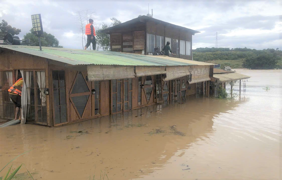 Cac luc luong vuot nuoc lu dang cao tiep can mot can nha bi co lap tai xa Ninh Gia de so tan nguoi dan den noi an toan. Anh: Phuc Khanh