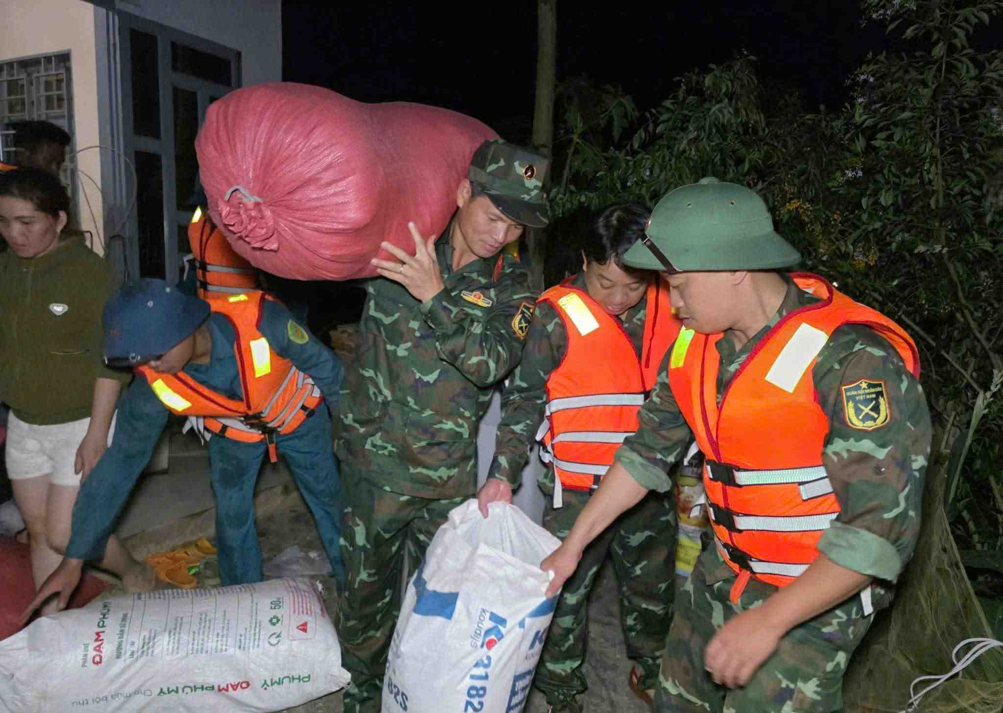 Can bo, chien si luc luong vu trang Lam Dong giup dan di chuyen tai san ra khoi khu vuc bi ngap. Anh: Phuc Khanh