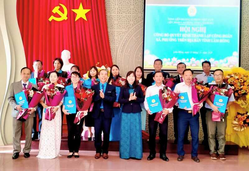 La Sra. Ha Thi Hanh - Miembro del Comite Permanente del Comite del Partido Provincial del Partido de la Patria de la provincia de Lam Dong (camisa negra) entrega flores para celebrar el aniversario de los presidentes de sindicatos de comunas y barrios. Foto: Le Hung