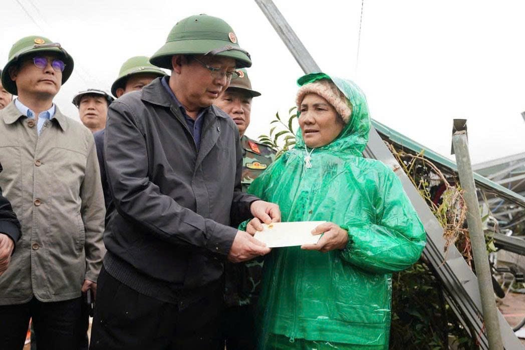 Pho Thu tuong Ho Quoc Dung an can tham hoi, trao ho tro cho nguoi dan bi thiet hai do mua lu tai xa D'ran. Anh: Phuc Khanh