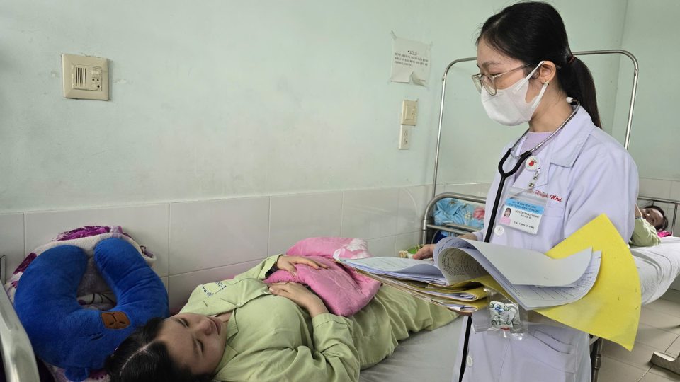 Ban co the dung chu thich anh 20 chu:Bac si tham kham, huong dan benh nhan phong ngua va dieu tri sot xuat huyet. Anh: Hoang Loc 