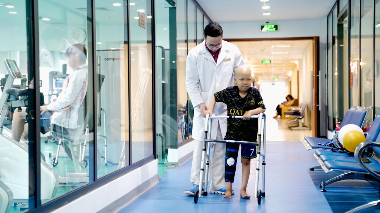 Hinh anh be Minh tap di bang dung cu ho tro sau phau thuat