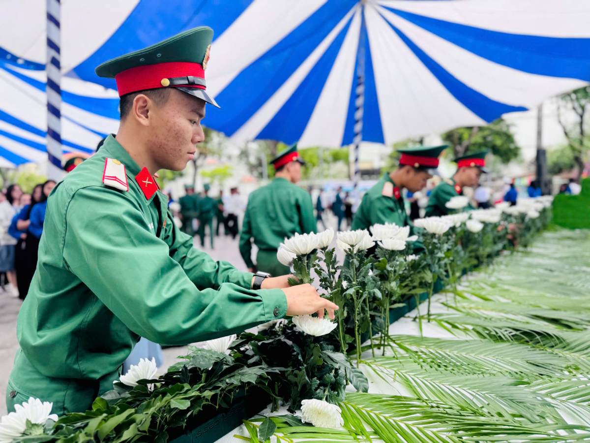 Nhieu nguoi dat hoa tuong niem cac nan nhan mat vi tai nan giao thong. Anh: Minh Tam