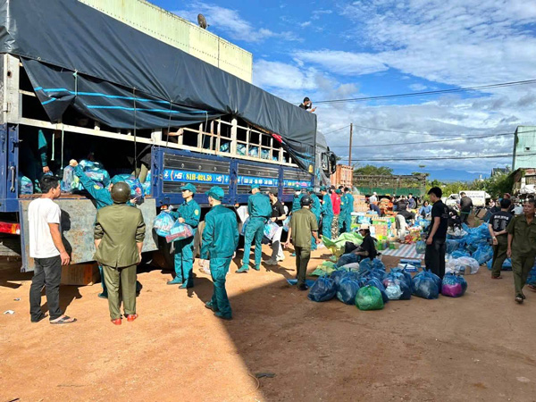 Dan quan va nguoi dan phuong Hoi Phu van chuyen nuoc, sua tuoi, gao cho ba con vung lu. Anh: Ba Binh 