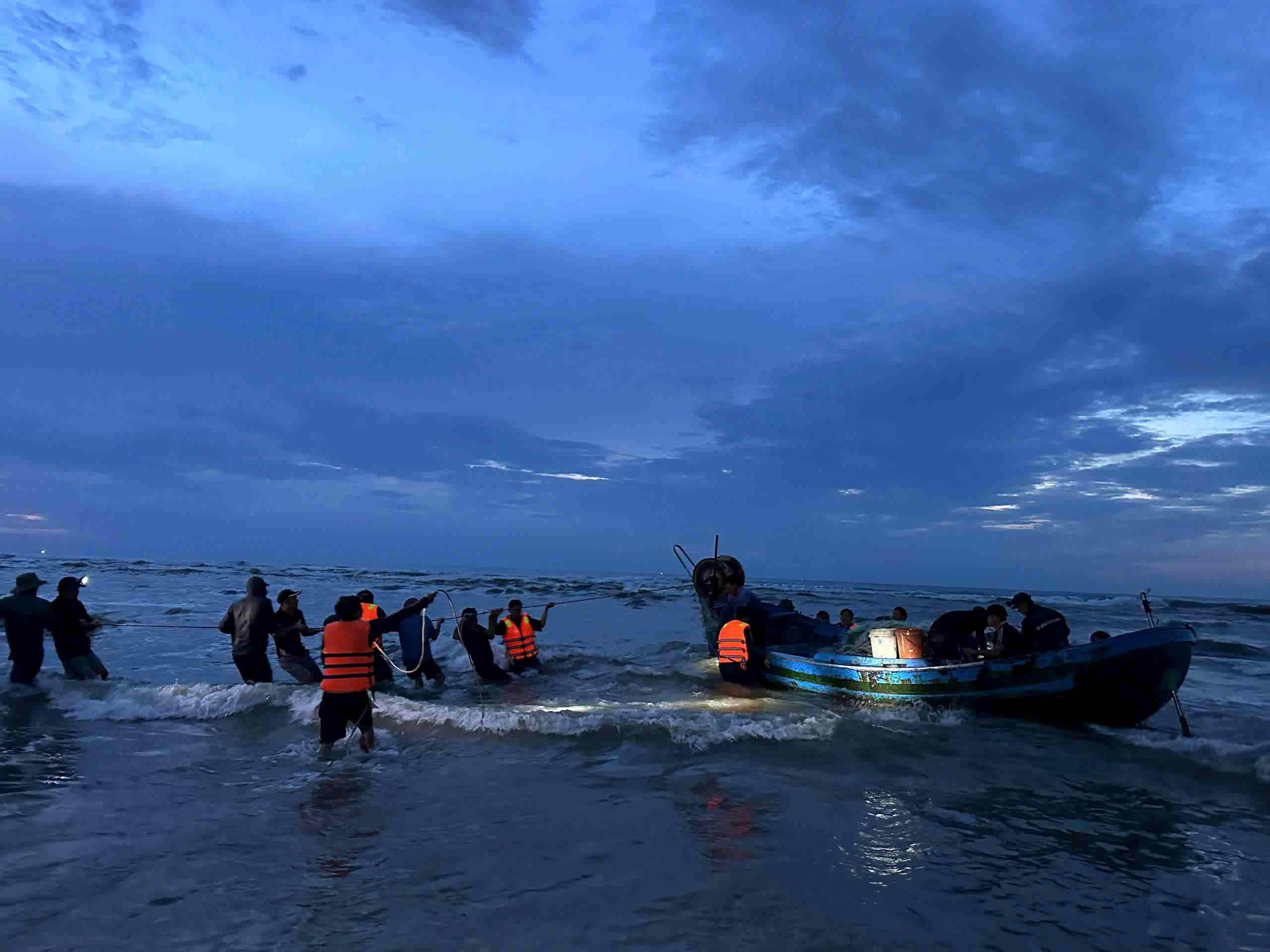 Border Guard forces and fishermen coordinated to pull the stranded ships in bad weather, big waves, and strong winds to the wharf safely. Photo: Van Hoan
