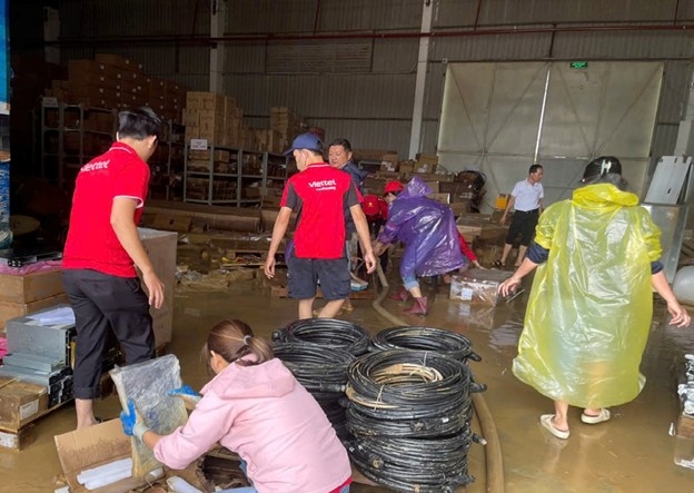 Kho vat tu cua Viettel cung bi ngap sau hon 1,5 m, can bo nhan vien tap trung don dep khi nuoc rut