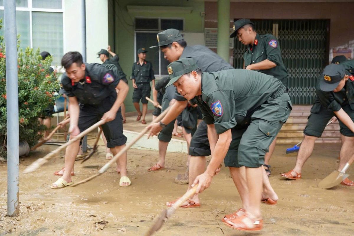 Cac chien si Canh sat Co dong giup nguoi dan don dep bun dat. Anh: Thanh Thuy