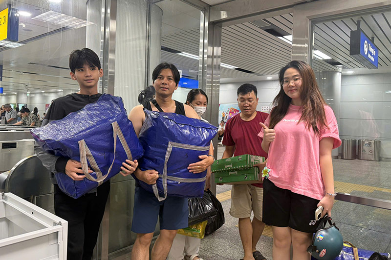 Nhieu nguoi dan mang quan ao cu, nhu yeu pham can thiet toi cac diem nhan doc tuyen Metro so 1 TPHCM. Anh: Thai Bao 