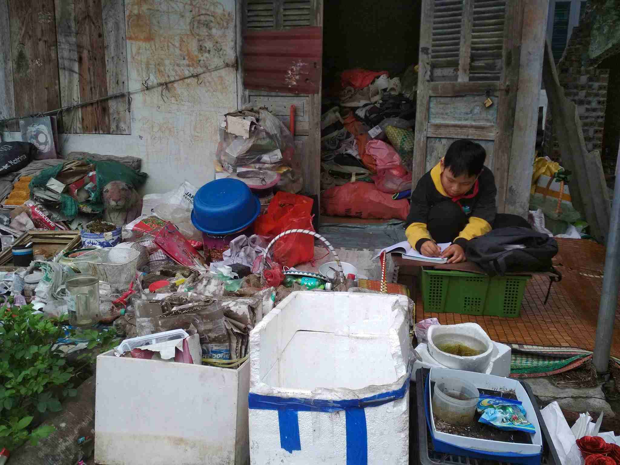 Bao lang le hoc bai tren chiec ban cu tai nha o Hai Phong, giua tieng on va mui rac. Tuoi tre An Thanh