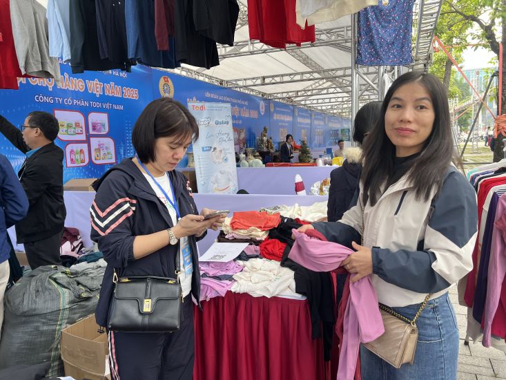 La Sra. Nguyen Thi Gam elige comprar ropa. Foto: Kieu Vu