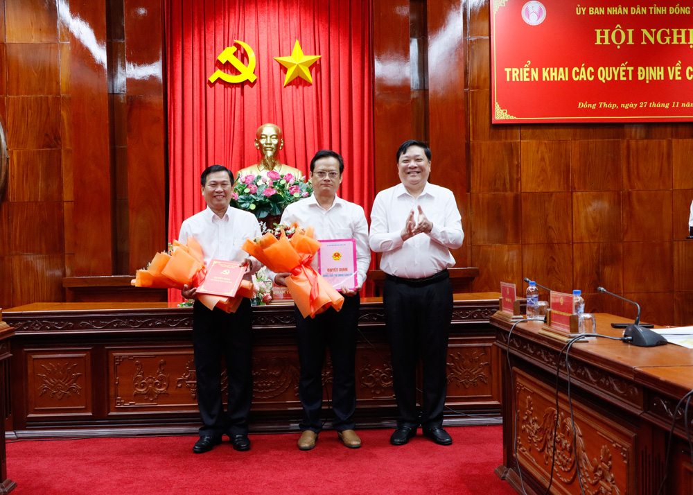 Chủ tịch UBND tỉnh Đồng Tháp Phạm Thành Ngại (bìa phải) trao quyết định và hoa chúc mừng cho ông Trần Ngô Minh Tuấn (giữa) và ông Phạm Văn An. Ảnh: Cổng Thông tin Đồng Tháp