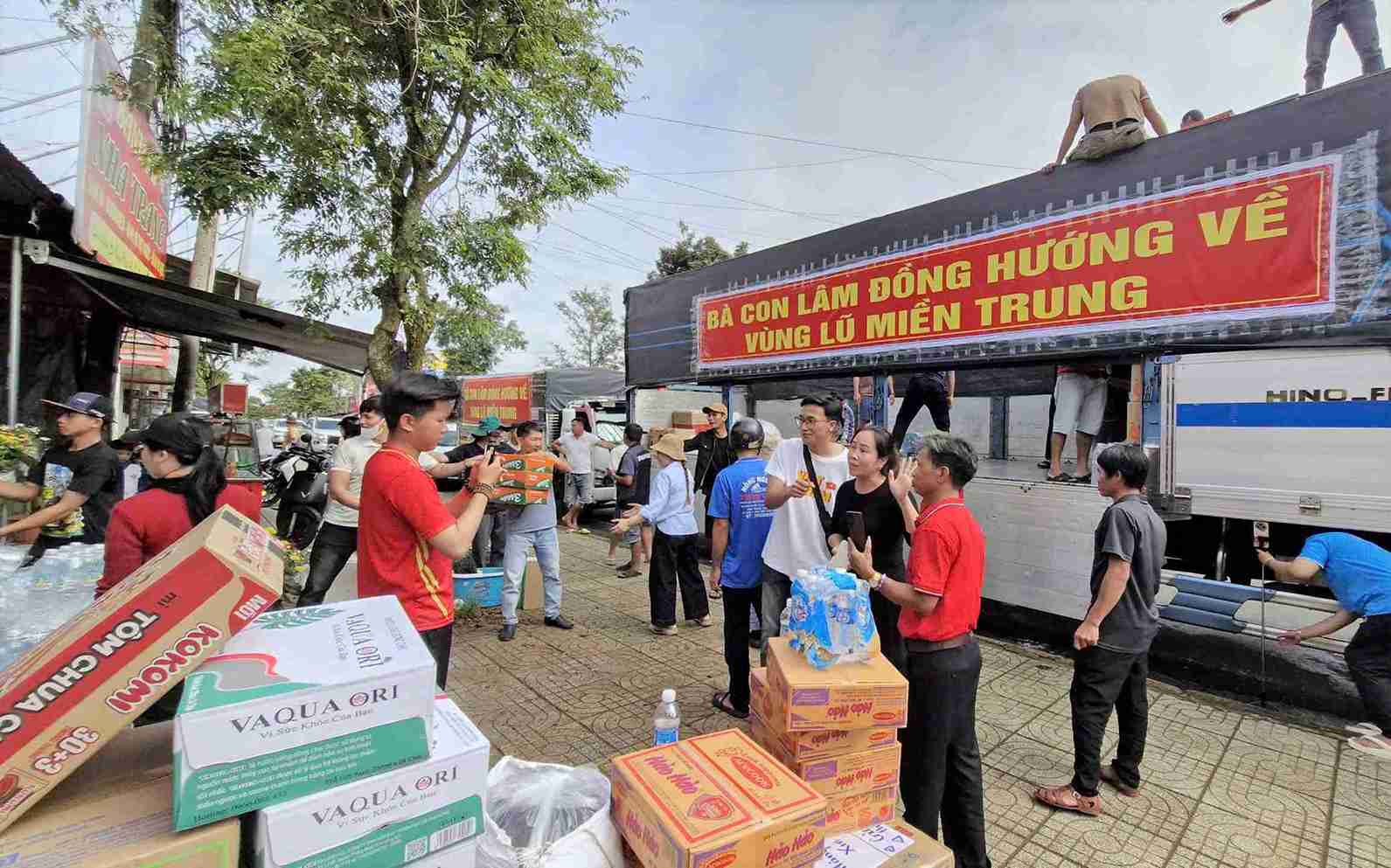 Moi nguoi mot tay chat hang hoa, nhu yeu pham len cac chuyen xe 0 dong huong ve dong bao vung lu. Anh: Phuc Khanh