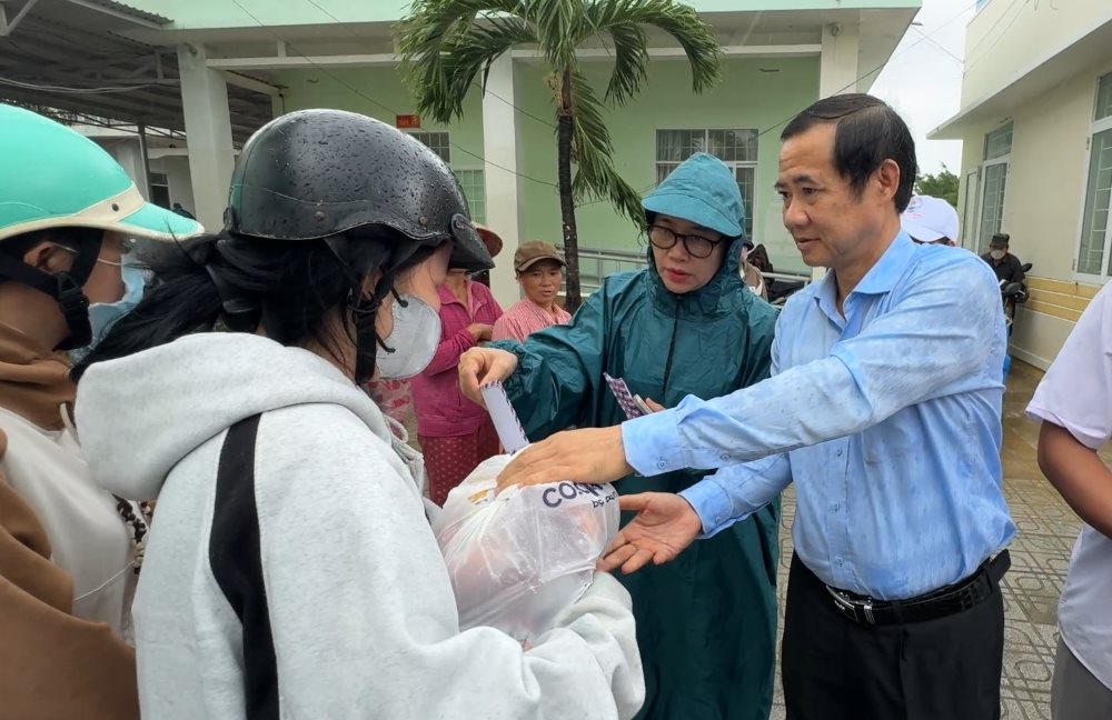 El Sr. Nguyen Thai Hoc - Subsecretario del Comite del Partido del Frente de la Patria de las organizaciones centrales - anima a la gente de las zonas inundadas de la comuna de Tuy An Dong provincia de Dak Lak. Foto: Huu Long
