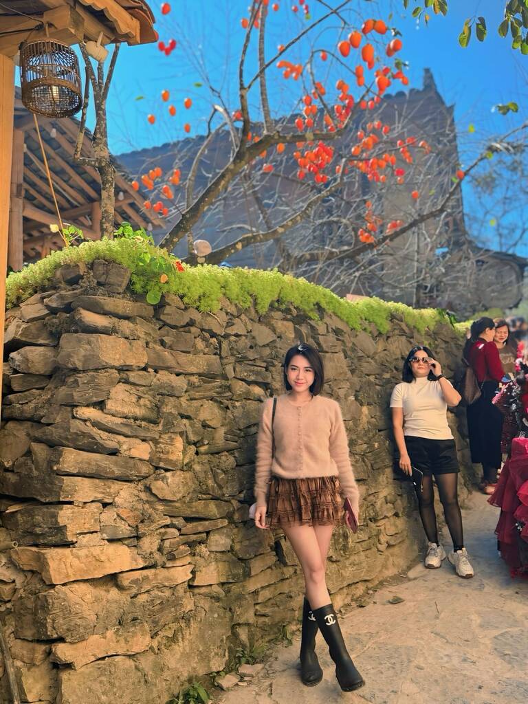 Nu du khach chup anh ky niem voi cay hong. Anh: Bui Thanh Tam